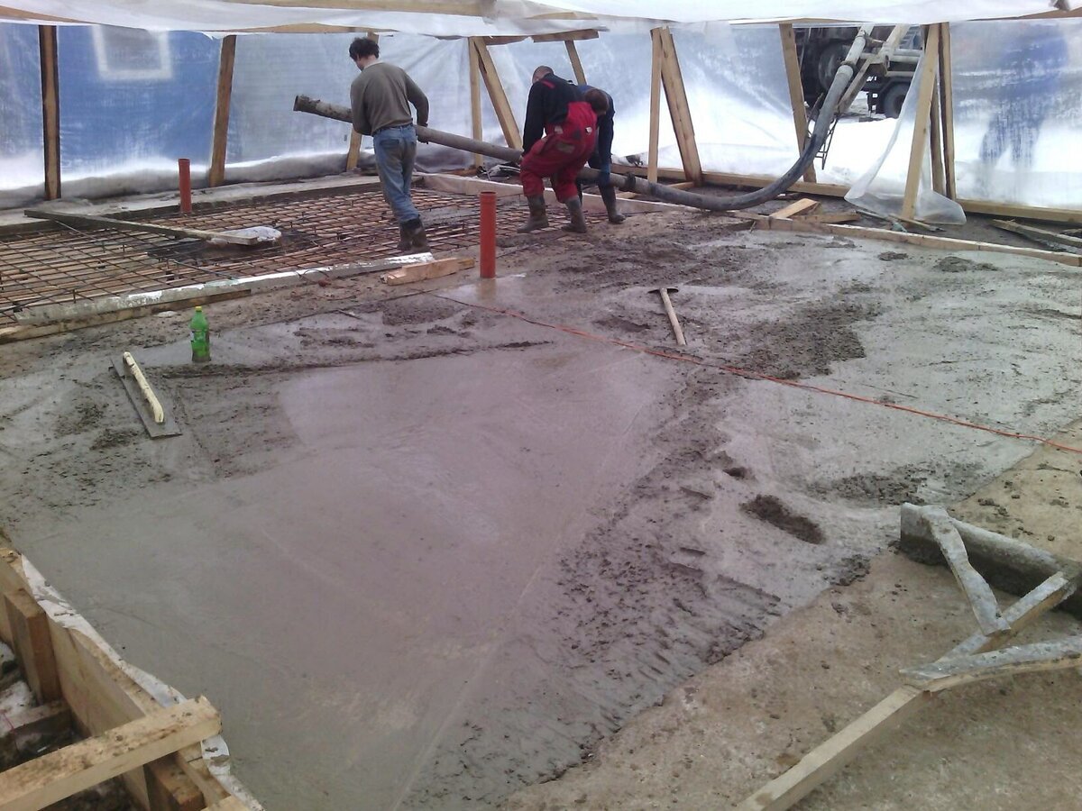 Заливка бетона бетононасосом. Зимнее бетонированных работ. Заливка бетона через поле с автобетононасоса шлангами.