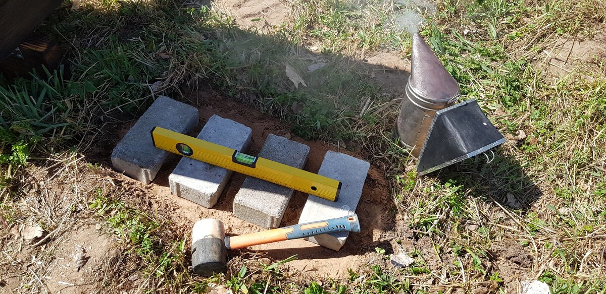 мало купить пчелопакеты или семьи, надо подготовить площадку под ульи да и саму подставку, место отсыпал песком, утрамбовал, уложил несколько кирпичиков тротуарной плитки и постарался выровнять по уровню