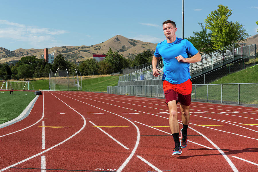 Спортсмен пробежал. Бег на стадионе. Бегущий человек на стадионе. Мужчина бежит на стадионе. Бег по стадиону.