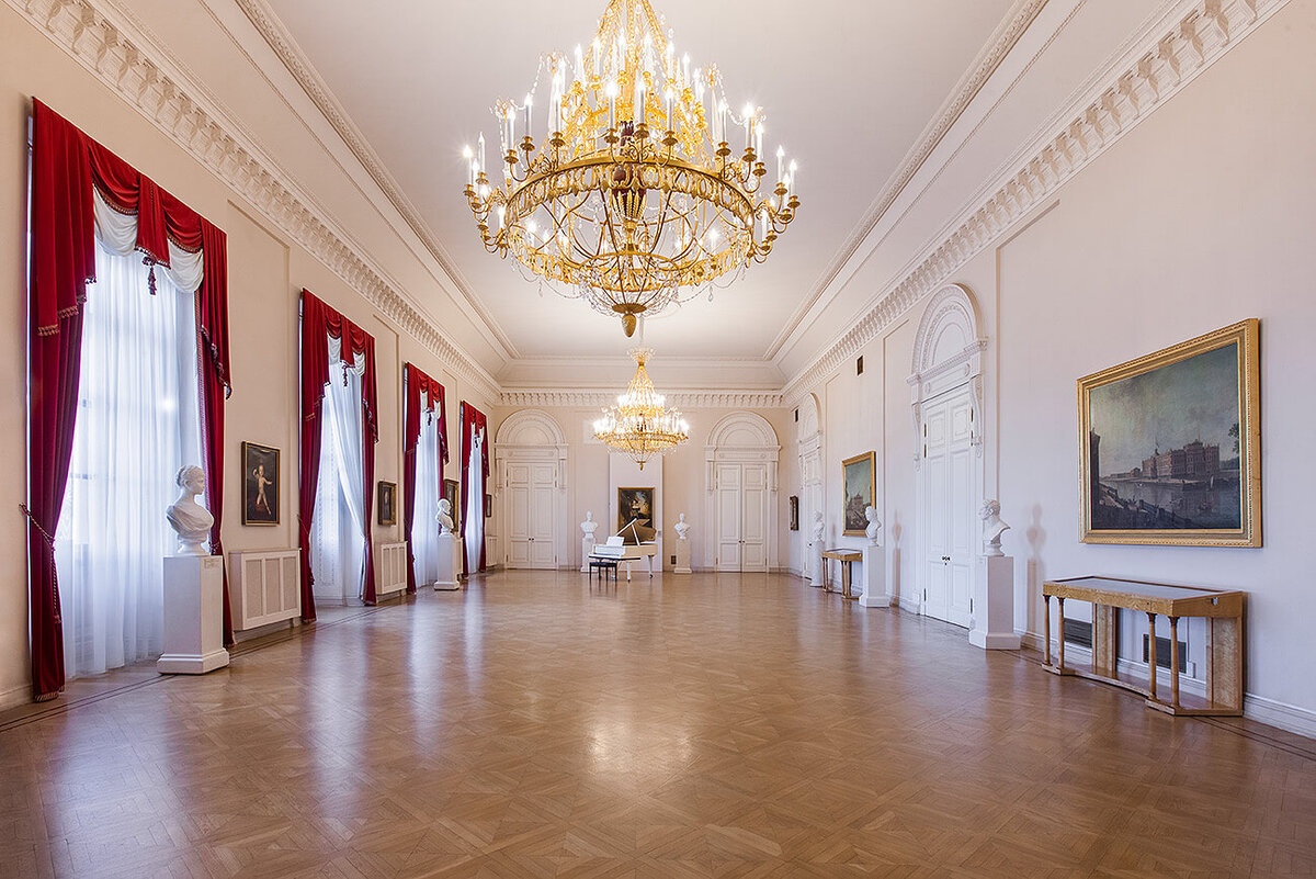 Михайловский замок столовый зал (современное фото). В этом зале прошел последний ужин Павла I. В наши дни отделка помещения воссоздана приблизительно (и довольно экономно), там, где на стенах были дорогие ткани и облицовка мрамором, в большинстве случаев сегодня штукатурка и обычная окраска стен. 