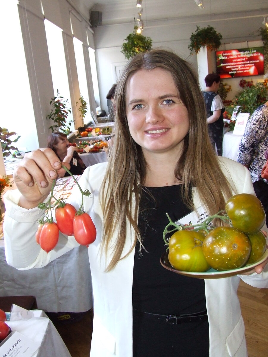 Дарья Юревич на выставке в Латвийском музее природы показывает свой урожай