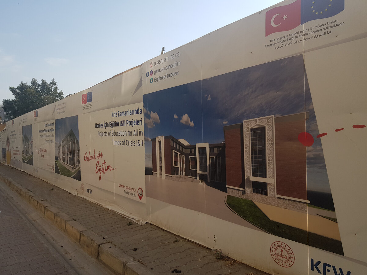 За забором стройка, в результате которой должна появиться школа для иранских (возможно, и из других "горячих точек") беженцев, - будет здание, как на проекте, напечатанном на ограждении вокруг места стройки.