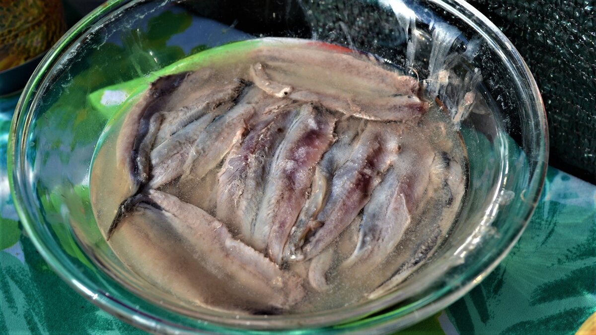 Этап приготовления свежемаринованной кильки. Филе кильки выстаивается в винном уксусе.