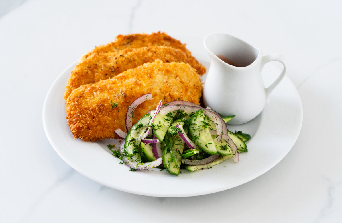 Шницель из куриной грудки с салатом из огурцов, красного лука и зелени