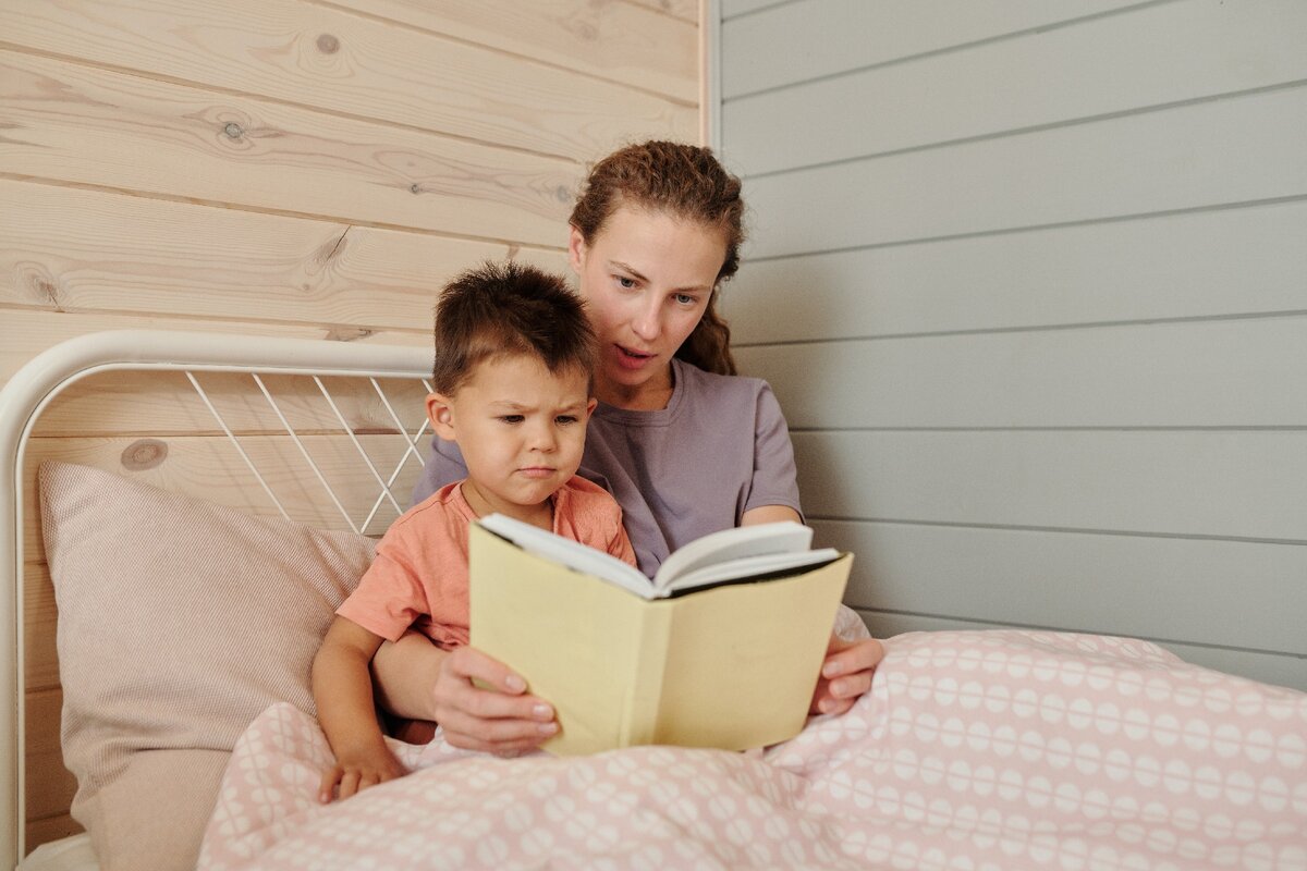 Дети портят жизнь. Дети с книжкой на кровати с родителями. Руки семьи на книге. Испорченные дети.