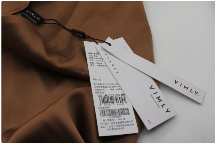 Сзади на внутренней стороне был пришит лейбл, на котором болтались картонные бирки магазина.