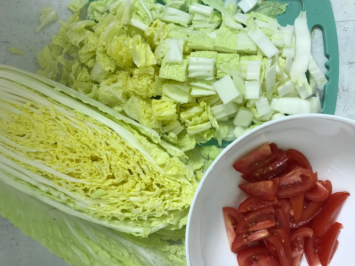 Нарезаем пекинскую капусту небольшими кубиками. Тонкими ломтиками нарезаем помидоры. 
