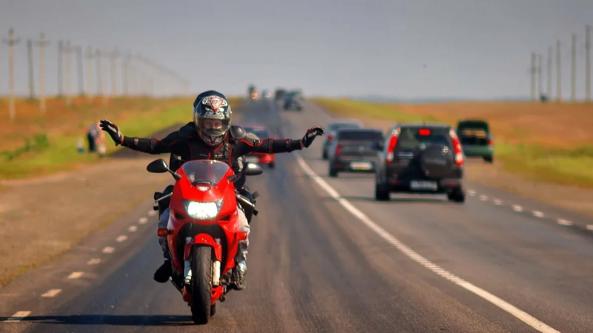 Мотоцикл едет по дороге. Мотоцикл на дороге. Мотоциклист на дороге. Мотоцикл едет. Байкер на дороге.