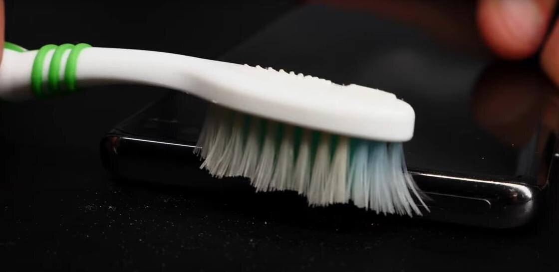    Динамик на телефоне чистят зубной щеткой:YouTube / Pedant.ru