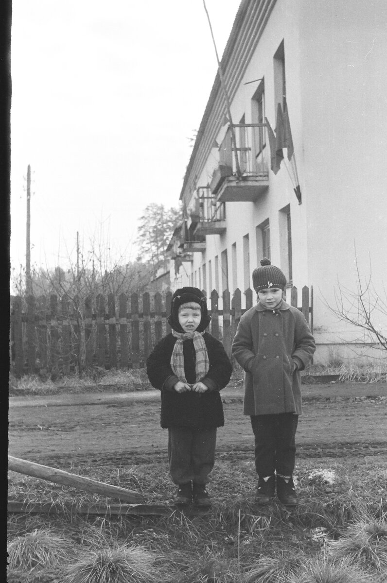 К стене дома прикручены специальные трубки, куда в советские праздники вставляли флаги. Как раз такой период. Примечание: на детях боты "Прощай молодость!"