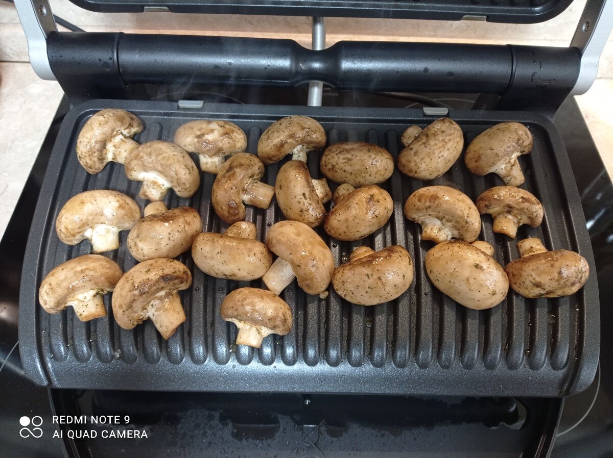 Гриль нагрелся, и мы выкладываем шампиньоны на панель, закрываем засекам 7 минут