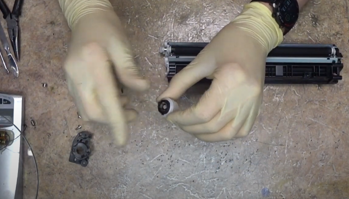 Фото 61. Вставляем пластик между роликом подачи тонера и уплотнителем