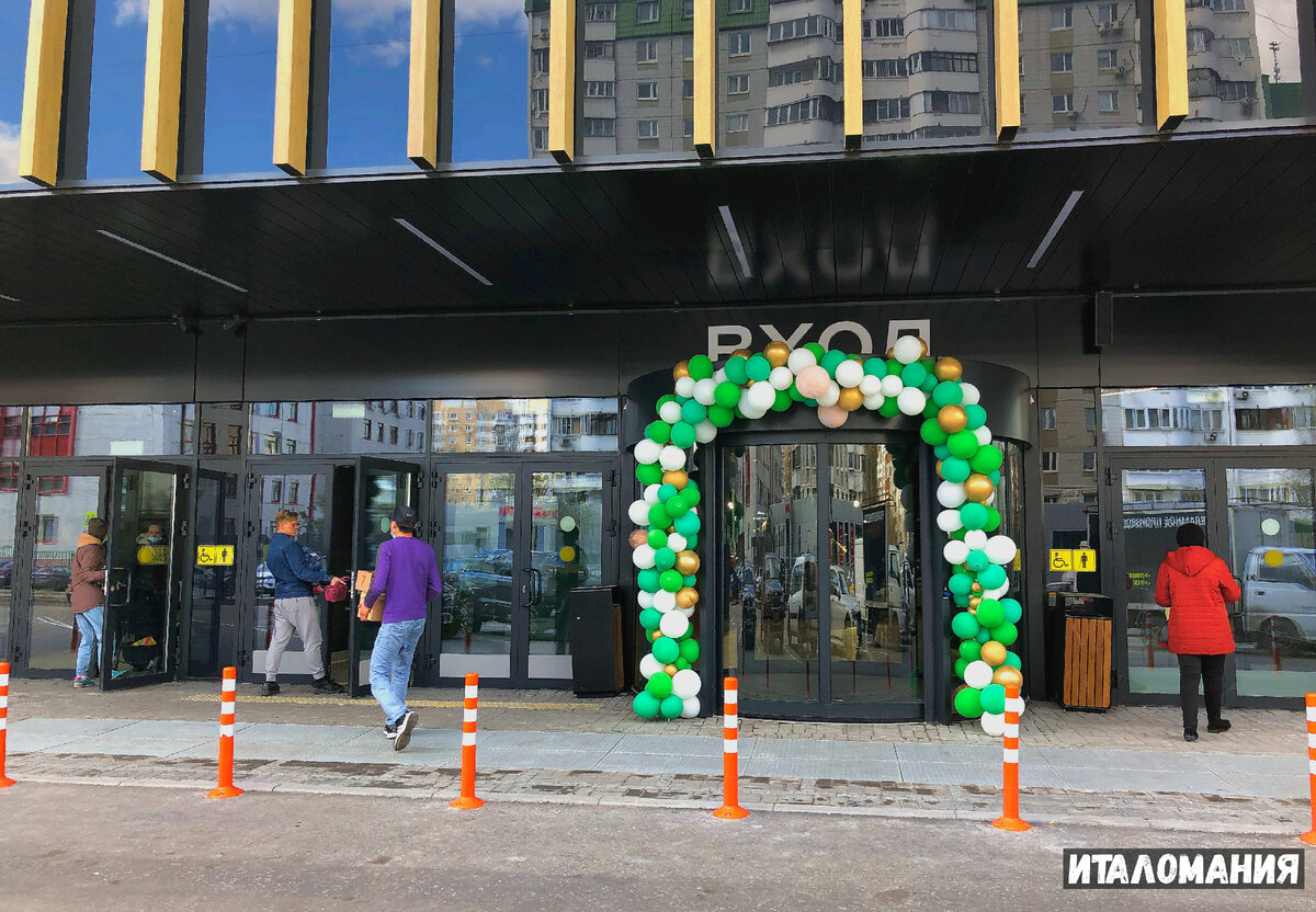 Вход празднично украшен шариками и ребята заносят ящики с продукцией. 