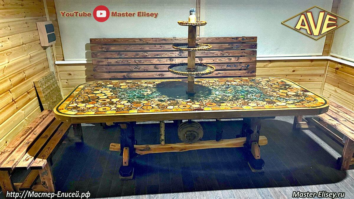 Стол из 30 пород дерева и всяко-разного:  еловые и сосновые шишки, мох, можжевеловые корни, ракушки разных видов, морские звёзды, листья цветов, соцветия, папоротник, одуванчики, цветы, древесные грибы и прочие "коряги",  кораллы и "жемчуга". 