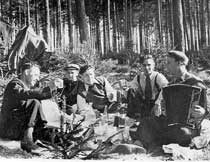 Немцы, словно саранча, заполонили все деревни вокруг Минска. А в лесу, в зарослях кустарника и даже во ржи прятались красноармейцы, попавшие в окружение. Над лесом, едва не задевая колесами верхушки деревьев, над хлебным полем кружил самолет–разведчик. Обнаружив бойцов, летчик поливал их из пулемета, швырял гранаты. Уже солнце садилось за лес, когда к нам с братом Леней, пасущим телят, подошел командир с группой бойцов. Было их человек 30. Я объяснил командиру, как выйти к деревне Волчковичи. И дальше двигаться вдоль реки Птичь. «Слушай, парень, проведи нас в эти Волчковичи, — попросил командир. — Скоро стемнеет, а ты ведь у себя дома...» Я согласился. В лесу мы наткнулись на группу красноармейцев. Человек 20 с полным вооружением. Пока командир проверял у них документы, я с ужасом понял, что потерял в лесу ориентир. В этих местах я только однажды был с отцом. Но с тех пор прошло столько времени... Цепочка бойцов растянулась на сотни метров. А у меня ноги подкашиваются от страха. Я не знаю, куда мы идем... Вышли к шоссе, по которому двигалась колонна немецких автомашин. «Ты куда нас привел, сукин сын?! — подскакивает ко мне командир. — Где твой мост? Где река?» Лицо перекошено от ярости. В руках пляшет револьвер. Секунда–другая — и пустит мне пулю в лоб... Лихорадочно соображаю: если Минск в этом направлении, то, значит, нам надо в обратном. Чтобы не сбиться с пути, решили идти вдоль шоссе, продираясь сквозь непроходимый кустарник. Каждый шаг давался с проклятием. Но вот лес кончился, и мы оказались на возвышенности, где паслись коровы. Виднелась окраина деревни. А внизу — речка, мост... У меня отлегло от сердца: «Слава Богу! Пришли!» Рядом с мостом — два обгоревших немецких танка. Над руинами здания курится дым... Командир расспрашивает старика–пастуха, есть ли в деревне немцы, можно ли найти врача — у нас раненые... «Были ироды, — рассказывает старик. — И дело черное сотворили. Когда увидели подбитые танки и трупы танкистов, в отместку подперли двери Дома отдыха (а там было полным–полно раненых) и подожгли. Нелюди! Сжечь в огне беспомощных людей... Как их только земля носит!» — сокрушался старик. Красноармейцы перебежали шоссе и скрылись в густом кустарнике. Последними ушли командир и двое пулеметчиков. У самого шоссе командир обернулся и помахал мне рукой: «Мы еще вернемся, парень! Обязательно вернемся!»