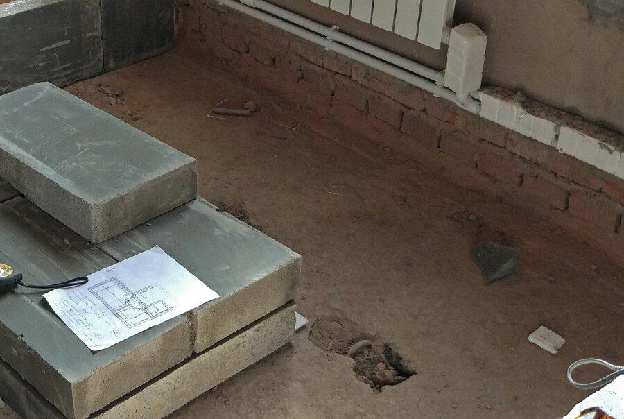 Не заделанное отверстие в полу. Нижняя част стены под трубами. Без штукатурки.