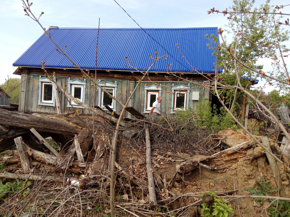 Наш деревенский дом в мае 2019 года. Крыша и окна новые, подключено электричество. Мой муж Николай делает рекогносцировку вокруг дома и разрабатывает план наступления на разруху.