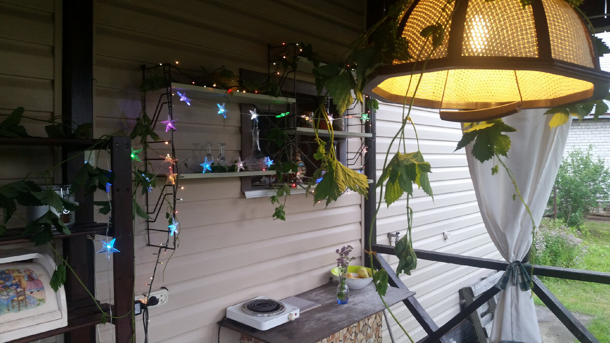 Огоньки на веранде могут работать и летом. А скошенный хмель украшает абажур так, как не украсит никакой дорогой декор. 