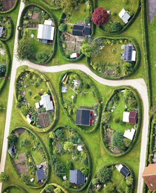 В 1948 году 40 овальных огородов, каждый размером примерно 25 × 15 метров, были разбиты на холмистой лужайке между жилыми домами с одной стороны и более традиционными постройками с другой. Первоначально Карл Сёренсен задумал проект ландшафтного дизайна как регулярную сетку овалов, разбросанных по поляне, но в итоге участки расположились более динамично, без какой-либо заданной последовательности.