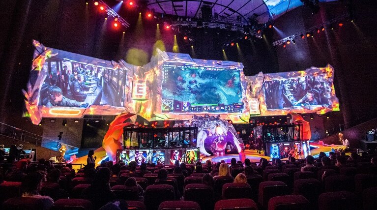 Что такое киберспорт

Если кратко, термин обозначает соревнование между людьми в видеоиграх. Участники пытаются доказать друг другу и зрителям, что в данном виртуальном мире именно они быстрее принимают решения, придумывают и реализуют лучшие стратегии, менее подвержены эмоциям. По сути, как в реальном спорте — футболе, биатлоне или любом другом виде.

При этом киберспорт очень гибок. В разных играх для победы нужно «нажимать кнопки» по-разному: в шутерах на первый план выходит скорость реакции, в карточных играх важнее общая стратегия на игру. Другие дисциплины требуют совместить эти таланты, взаимодействовать с партнёрами по команде, уметь прочесть противника и сохранять хладнокровие до решающего момента.

Зародился киберспорт ещё в 1990-х — геймеры стремились стать лучшими во дворе, компьютерном клубе или в городе. Энтузиазм игроков и зрелищность позволили хобби довольно быстро развиться в огромную индустрию: теперь за битвами лучших игроков и команд следят миллионы зрителей, а самые успешные зарабатывают сотни тысяч долларов и получают огромную известность среди сверстников.

Особенно популярен киберспорт стал во время пандемии COVID-19: пока все спортивные соревнования отменяют или проводят со значительными ограничениями, геймеры продолжают выступать в онлайн-формате — играют матчи по интернету не выходя из дома. Доступность киберспорта всегда была большим плюсом — чтобы тренироваться, игрокам не обязательно каждый день приходить на стадион или собираться на базе. Всё для этого уже есть в виртуальном мире, доступном из квартиры каждого участника.

В 2021 году соревновательный гейминг успешно закрепился как один из самых популярных и развитых видов спорта. До футбола или франшизных лиг уровня НХЛ пока не достать, но киберспорт как направление уже перспективнее велоспорта, лыжных гонок или гандбола — это касается и призовых, и внимания аудитории, и иных моментов.

Важно и то, что киберспорт не требует больших денежных вложений, связей и так далее. Это очень честное соревнование — побеждает тот, кто лучше справляется с задачей, а арбитром выступает компьютерная система. Успеха добиваются простые парни, с которыми можно легко пообщаться в рейтинговом матче или на стриме. Возможность стать чемпионом мира в следующем году в теории есть у каждого.