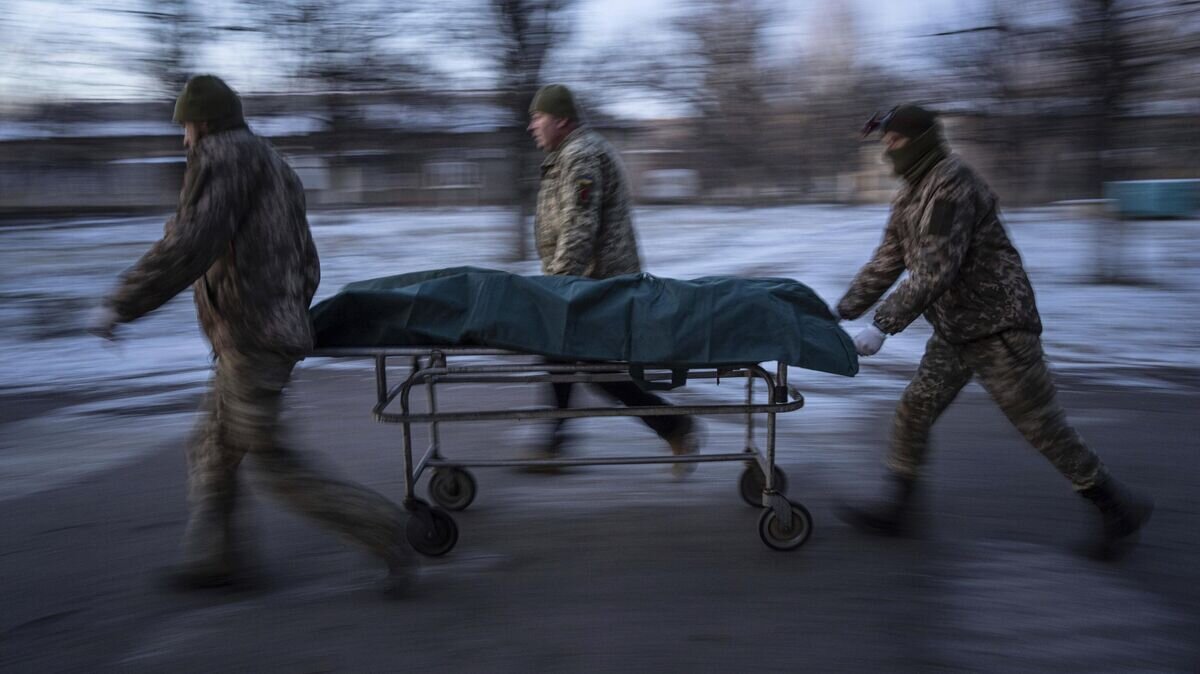    Украинские военнослужащие перевозят носилки с погибшим в Донецкой области© AP Photo / Evgeniy Maloletka