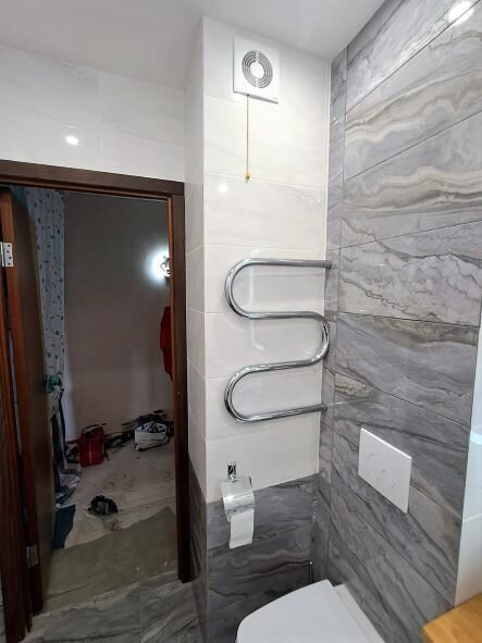 Санузел "После" завершения отделочных работ: кафель уложен на поверхности, оборудование смонтировано и закрыто в коробе из гипсокартона. Фото из собственных источников.