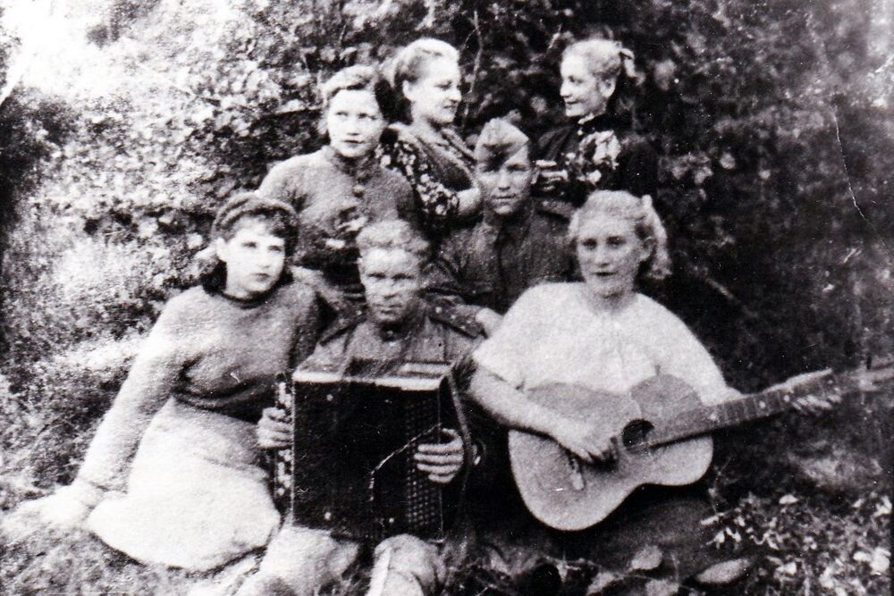 Фото из конверта: "Аня Черногубова, Миша-баянист, Галя Ловцова с гитарой, Аня Крупорушникова, л-т Корнилов, неизвестная девушка и Аня Ануприенко. Июль 1944. д. Прибрежье. Белоруссия". Из письма Галины Ловцовой. Фото: Из архива Дмитрия Шеварова 