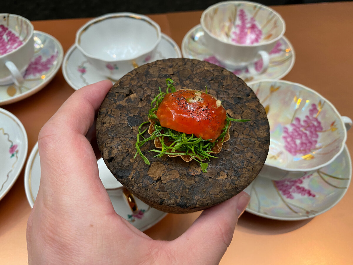 Приветственный комплемент: тарталетка с помидорной сердцевиной, предметом культа Мухина. В дулёвском фарфоре подают игристое. 