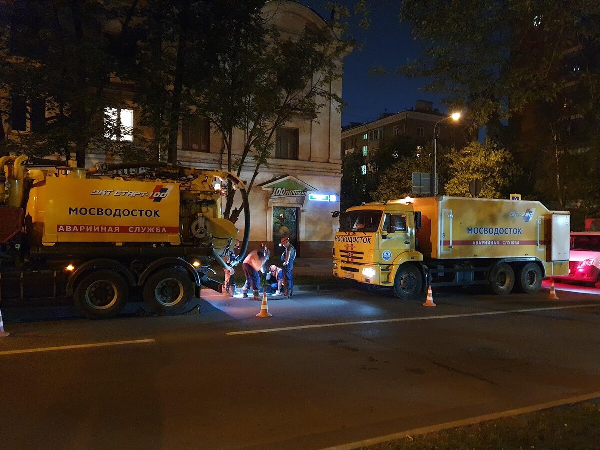 Рабочие аварийной службы очищают колодец ливневой канализации от асфальта. Источник: Facebook / Артемий Федин