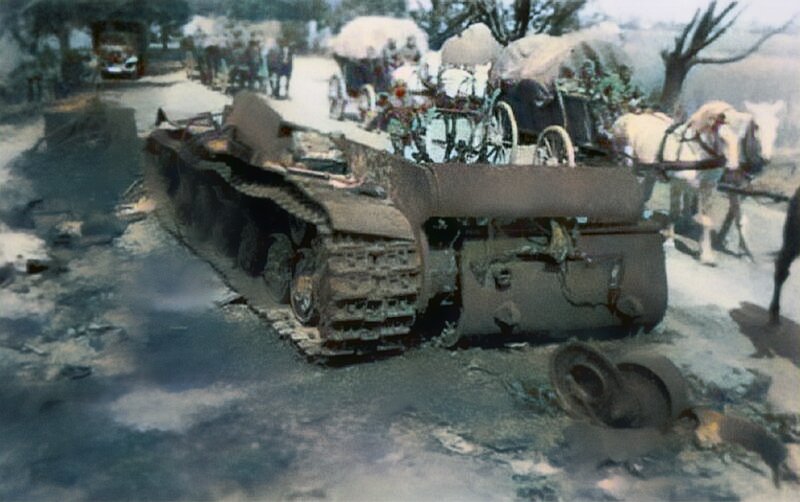 Немецкая колонна проезжает мимо советского тяжелого танка КВ-2, взорванного собственным экипажем 27 июня 1941 года при отходе 41-й танковой дивизии из Ковеля.