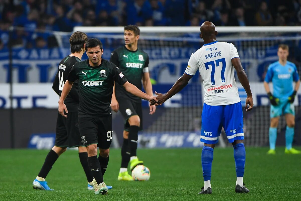 фотография из матча между Краснодаром и Динамо в рамках чемпионата России по футболу. На картинке изображены: молодое дарование краснодарского футбола Шапи Сулейманов и легионер московского клуба Каборе. 