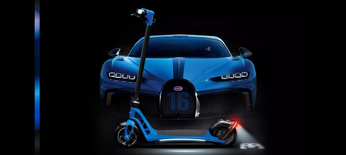 А это электросамокат Bugatti. Стоит он, конечно,  не столько много, сколько гиперкар Chiron на заднем плане, зато его нельзя купить - тем более в России и нынешних реалиях. 