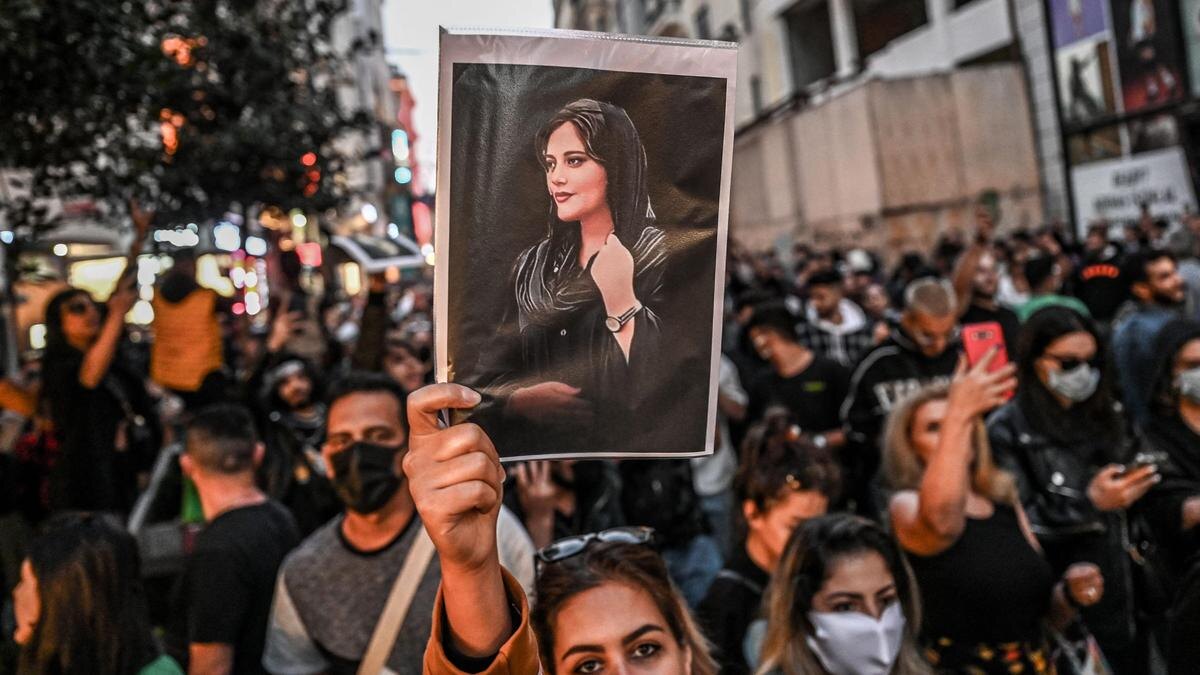    Фотографии Махсы Амини в руках протестующих:OZAN KOSE/AFP via Getty Images