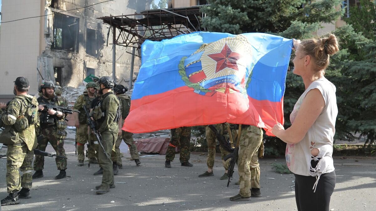    Местная жительница с флагом ЛНР у здания администрации в Лисичанске© РИА Новости / Виктор Антонюк