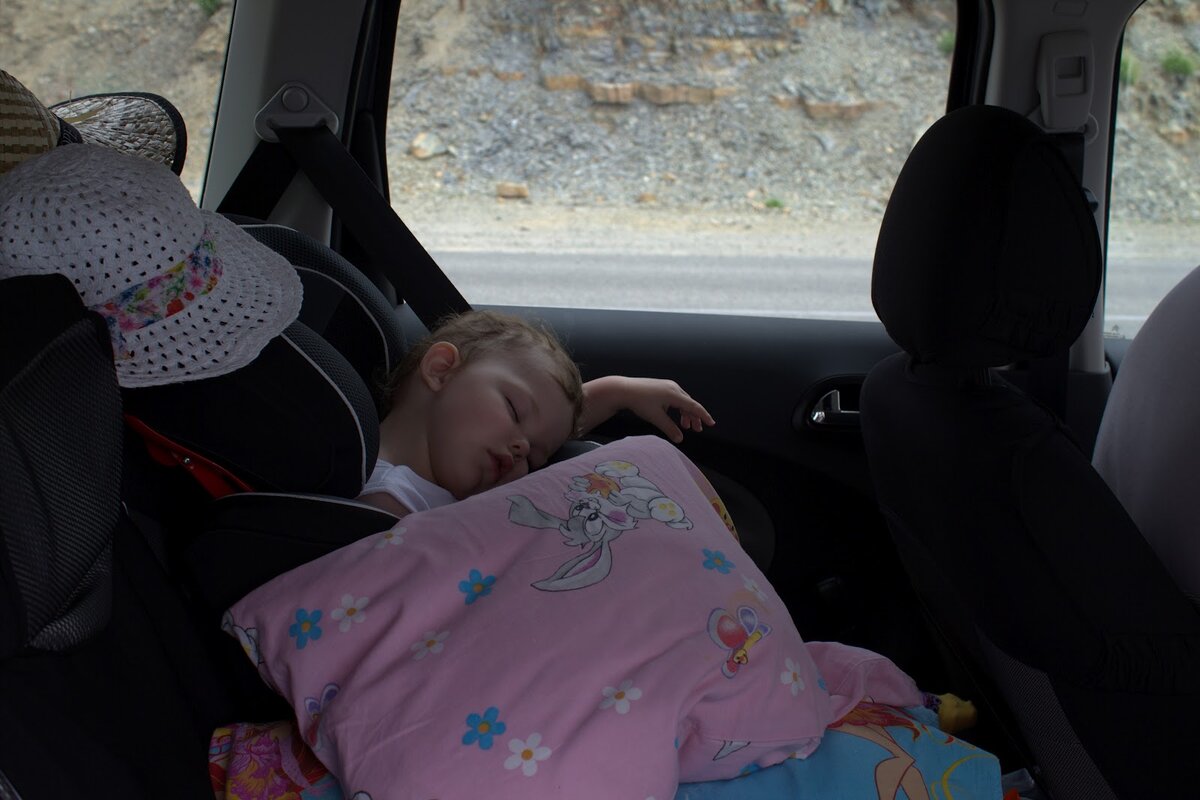 Ребенок спит в машине