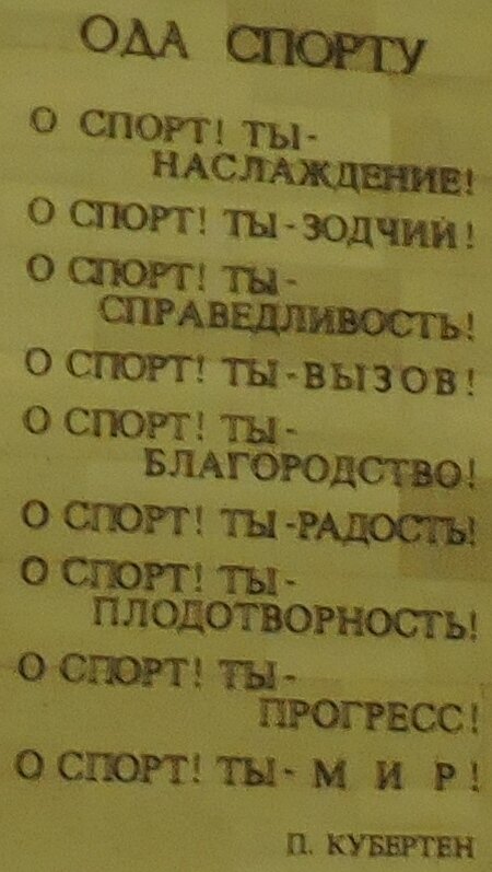 «Ода Спорту» Пьера де Кубертена в торцевой стене верхнего яруса.
