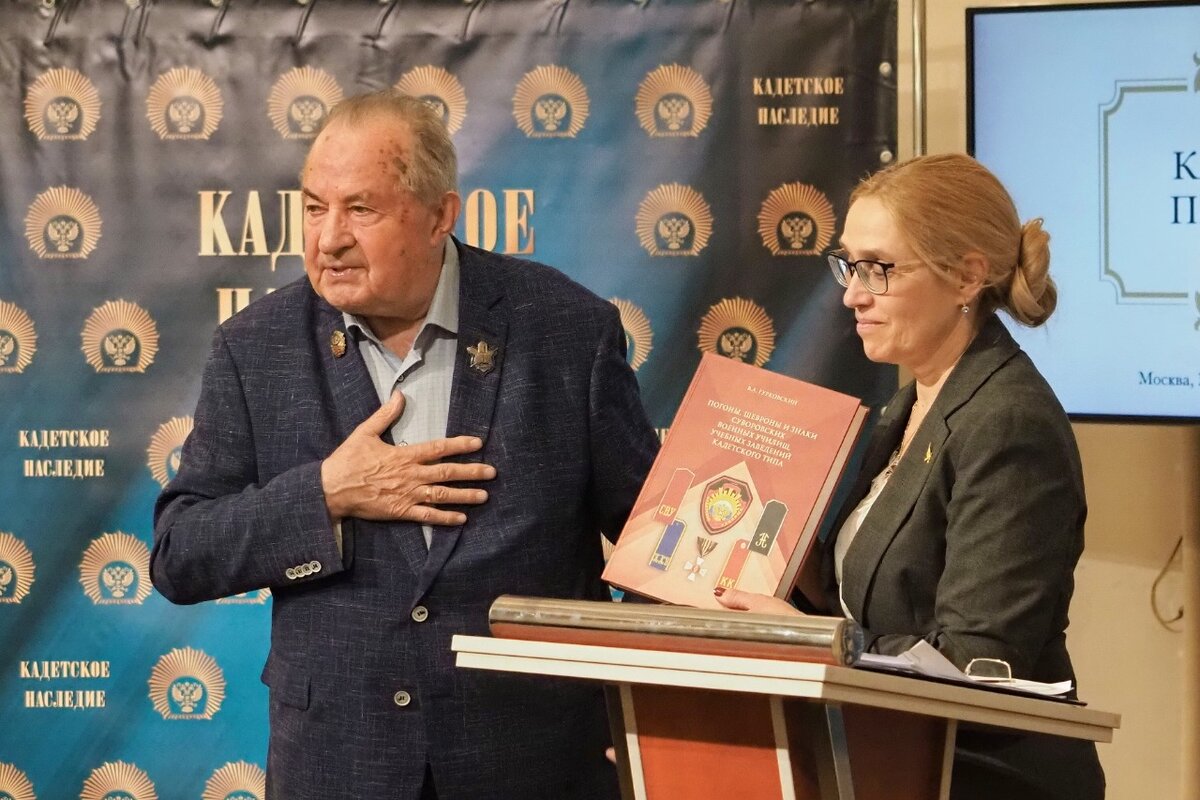 Владлен Гурковский - выпускник суворовского училища, кандидат исторических наук, автор многих трудов по истории кадетских корпусов России, член Союза писателей России дарит директору Музея военной формы Елене Синицыной одну из своих книг.