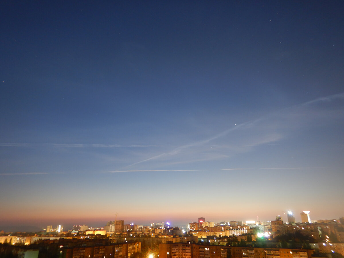 Следы от самолётов подсвечиваются Солнцем из-под горизонта. Листайте галерею.