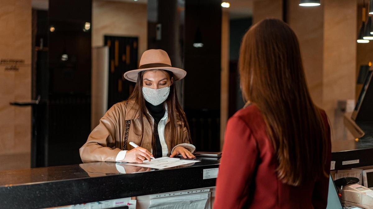    Девушка подписывает документы при въезде в отель:pexels.com