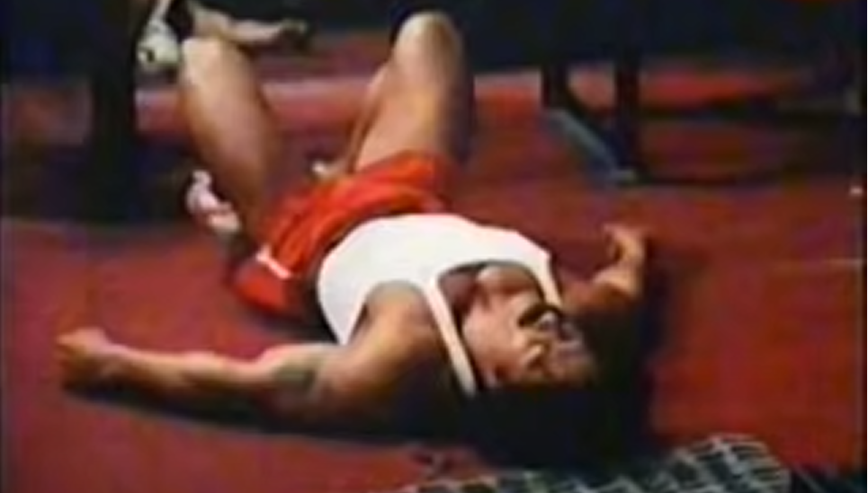 Эд Корни лежит на полу после приседаний  с Арнольдом в фильме "Качая железо"