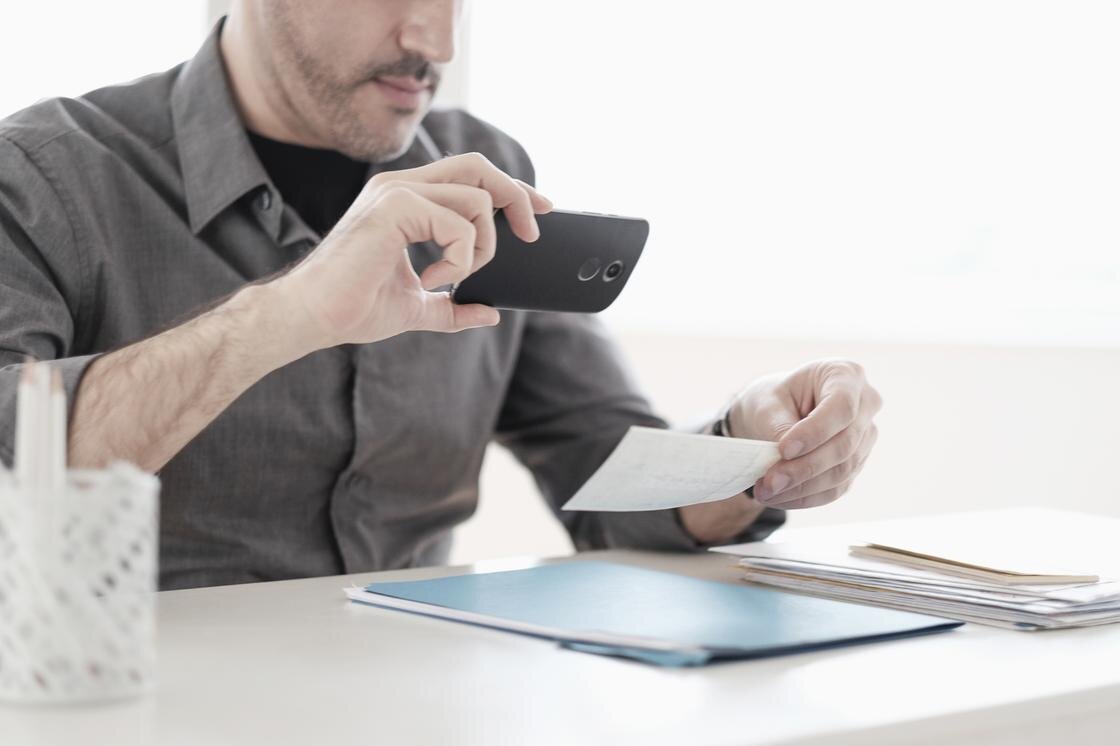    Мужчина фотографирует документ:Tetra Images/Getty Images