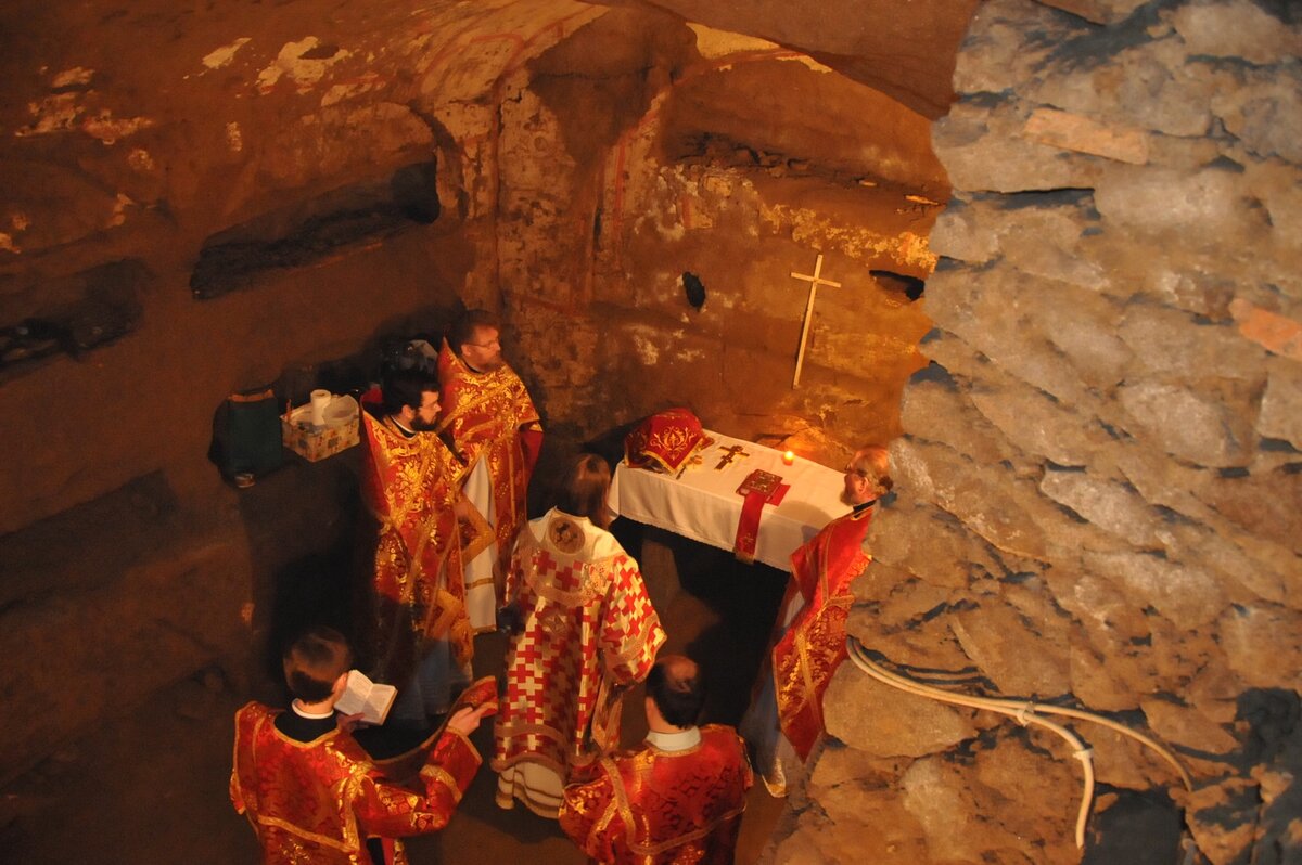 Совершение Божественной Литургии в катакомбах святого Панкратия на Яникульском холме. Датируемые началом II века по Рождестве Христовом, эти катакомбы были одним из мест молитвы римских христиан в эпоху гонений, где так же совершались службы.
