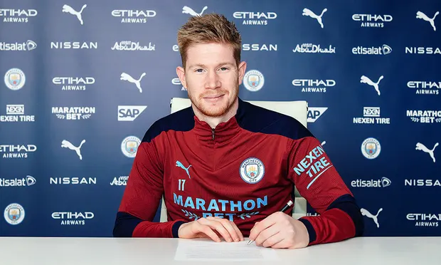 Kevin De Bruyne signs the deal that is due to keep him at Manchester City until 2025. ‘This football club is geared for success,’ he said. Photograph: MCF