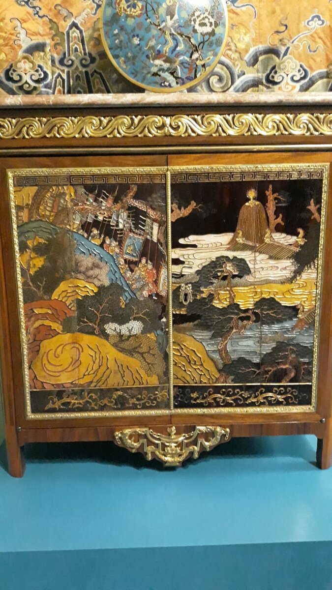 Этот Шкафчик когда-то именно в этом зале Дворца и стоял, а теперь его привезли из Эрмитажа в гости. Это эксклюзивная вещь. Дверцы сделаны из китайской ширмы, которая изготовлена была по очень древней технологии.