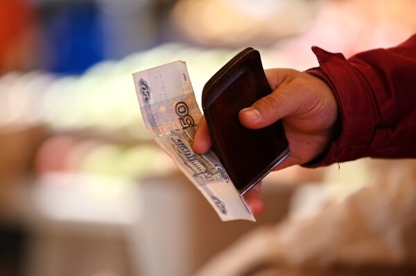 Покупатель оплачивает покупку на продуктовой ярмарке в микрорайоне Мацеста в Сочи