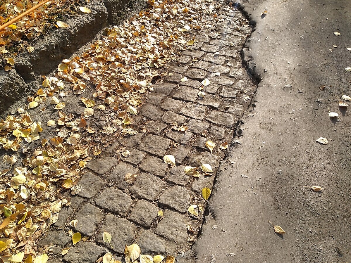 Брусчатка проступила сквозь многолетние слои асфальта, а ее опять в асфальт закатали(((