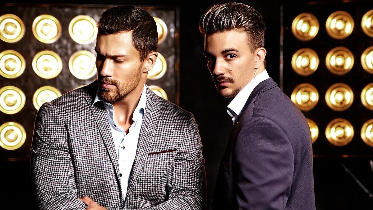    Мужчины-модели позируют на фоне софитов:Freepik