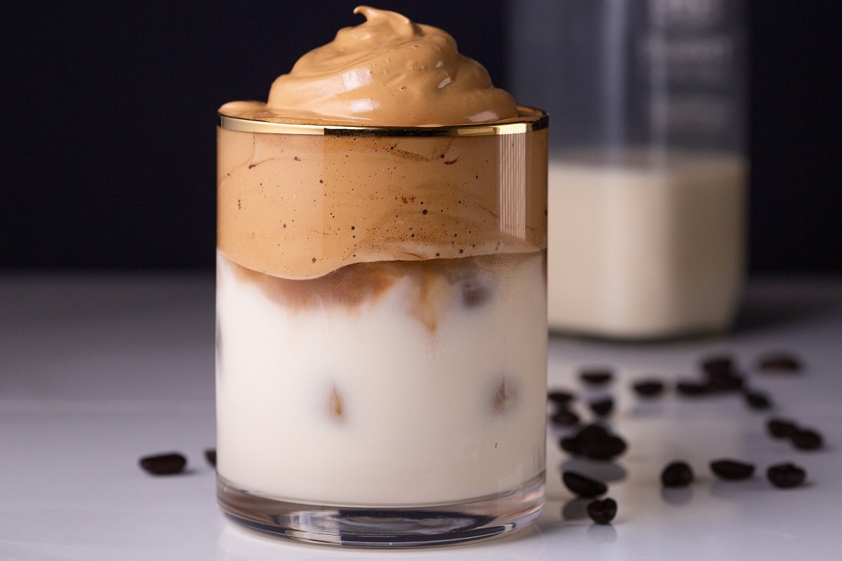 Продукты Кофе растворимый – 7 ст. ложек
Сахар – 7 ст. ложек
Вода (тёплая) – 85 мл
Какао-порошок – 1 ч. ложка
Молоко – по вкусу
Лёд – по вкусу                                                                                                                                                                   Все продукты берутся в равных количествах, отмерял мерной чашкой. Для вас переведу в столовые ложки и миллилитры. Кофе - обычный растворимый, вода - кипяченая (тёплая). 
В удобной большой чашке смешиваем кофе с сахаром. И понемногу добавляем воду (буквально по столовой ложке), при этом взбиваем венчиком.
Как только изменится цвет, можно добавлять следующую порцию воды. И так вводим её всю постепенно.
Взбиваем до блестящей, плотной массы. Можно воспользоваться миксером, блендером, но лучше венчиком. На это уходит 2-3 минуты.
Первый вариант: наливаем молоко в стакан и сверху кладём 3 большие ложки кофейной массы.
Второй вариант: в три ложки кофейной основы вмешиваем ложечку какао.
Наполняем стакан молоком и перекладываем сюда сверху кофейно-шоколадную основу. Классно получается, такой вариант мне нравится больше всего.
Третий вариант – для летнего жаркого дня. Вместе с молоком в стакан добавляем кубики льда.
И сверху кладём волшебную кофейную массу!
Всё очень легко, просто и невероятно вкусно!