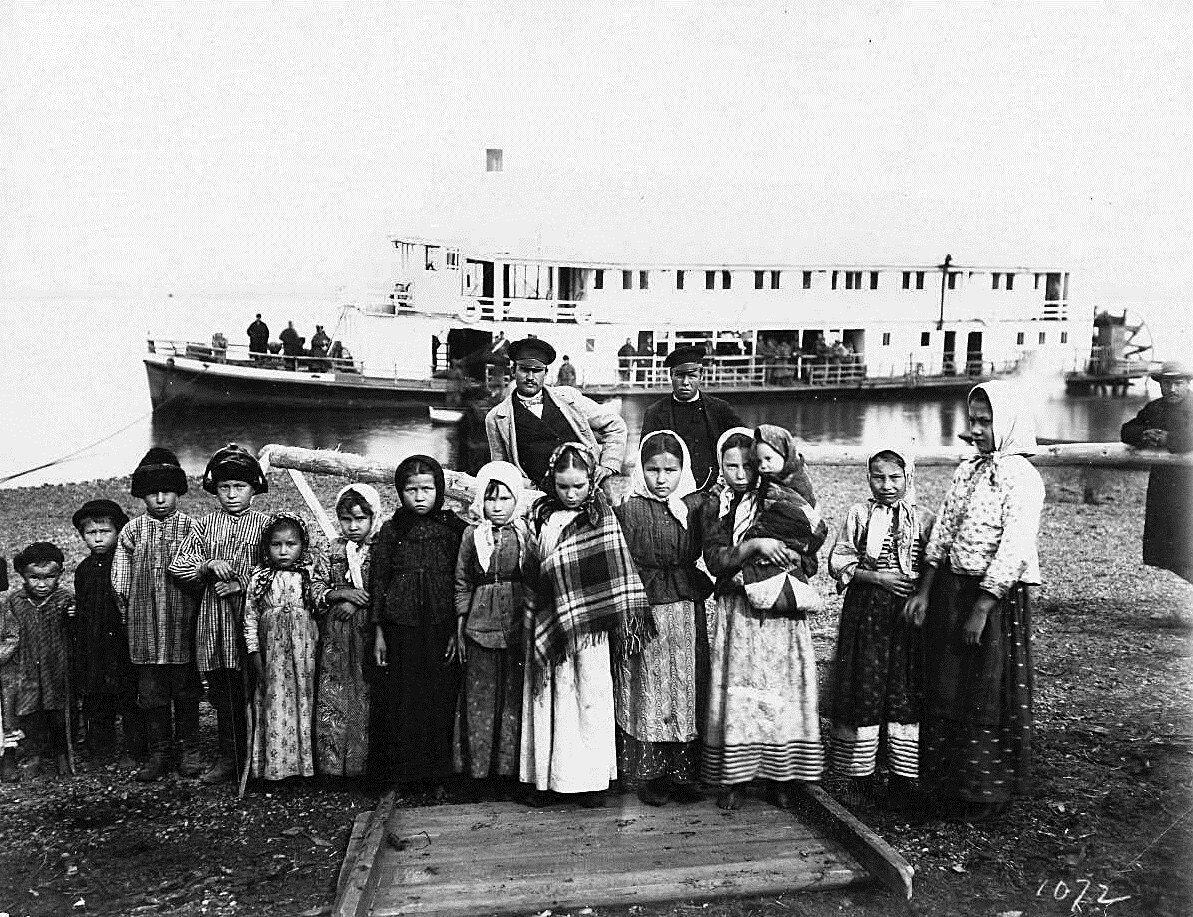 Фотография сделана Уильямом Генри Джексоном - американским фотографом и исследователем. Его карьера фотографа — с 12 до 99 лет — по всей вероятности самая продолжительная за всю историю фотографии. В 1895 Джексон проехал по маршруту строящейся магистрали по заданию Всемирной транспортной комиссии. Результат - тысячи фотографий и зарисовок, сотни из которых посвящены Транссибу. Это и портреты строителей - инженеров и каторжан, и фотографии местных жителей - рыбаков, охотников, ямщиков, и снимки сибирских городов, первых мостов и вокзалов. На фото группа казачьих (крестьянских) детей на реке Уссури, 1895-96 г.г., с. Иман (ныне г. Дальнереченск).

