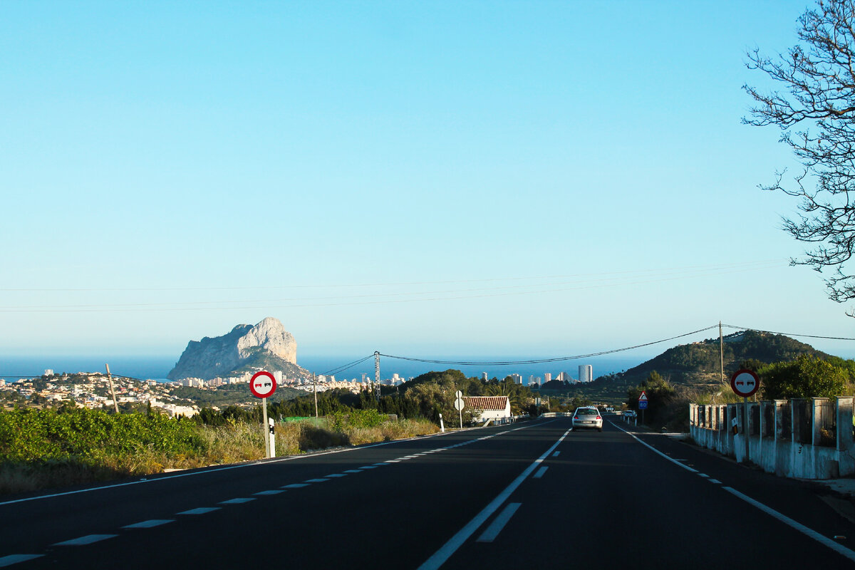 Едем по трассе в сторону Бенидорма, впереди за скалой на фоне моря Кальпе.